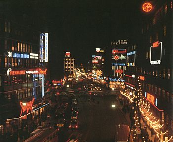 Kungsgatan i julebelysning 1965 og 2010 med vy vestpå fra Malmskillnadsbron. 
 Længst til højre ses facaden for Centrumhuset, tegnet af Cyrillus Johansson og i baggrunden hjørnet af ejendommen Hästhuvudet 13. 
 Til venstre skimter biograf Royal hvor filmvisningen blev lagt ned i 2007. 
 Ud over lysreklamen har ikke meget ændret sig; 
 SFs runde røde neonskilt fandtes allerede der i 1940'erne.