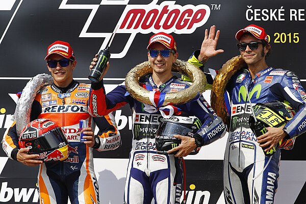 Marc Márquez, Jorge Lorenzo and Valentino Rossi, celebrating on the podium after finishing second, first and third at the MotoGP race.