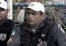 Photographie en gros plan d'un homme en uniforme de policier et portant une casquette blanche.