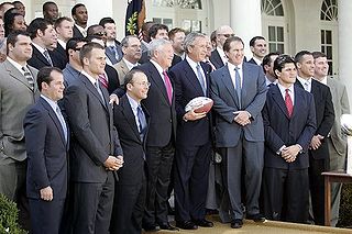 A large group of men standing together, including George Bush and Robert Kraft in the middle.