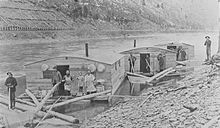 Three arks for a log drive on Pine Creek in Lycoming County or Tioga County. The left ark was for cooking and dining, the middle ark was the sleeping quarters, and the right ark was for the draft horses. The arks were built for just one trip down river and then dismantled and sold for their lumber. The line of the Jersey Shore, Pine Creek and Buffalo Railway can be seen on the eastern shore, and the mountainside behind it is nearly bare of trees from clear-cutting. Pine Creek Arks.jpg