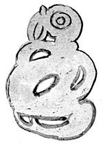 A flat greeenstone ornament formed of a bird-headed monster with two claws on it’s leg.