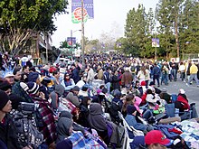 Spectators gather before the 2004 Rose Parade: some pay for seats in stands; others spend the night to "reserve" a free spot on the sidewalks. PreRoseParade-010104.jpg