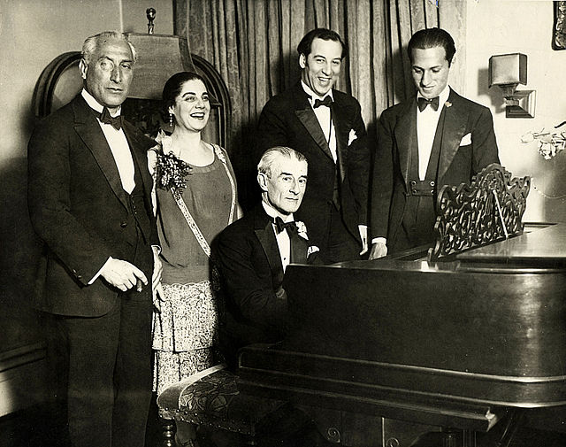 Birthday party honoring Maurice Ravel in New York City, March 8, 1928. From left: Oskar Fried; Éva Gauthier; Ravel at piano; Manoah Leide-Tedesco; and