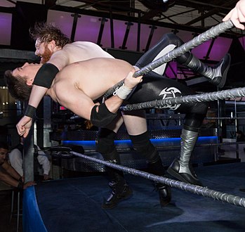 Josh Rogen clotheslines Eric Cairnie over the top rope and out of the ring.