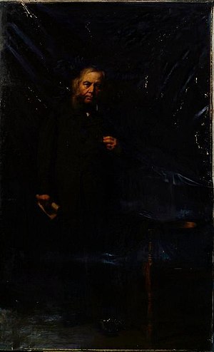 painting of Alexander Anderson, by Sir George Reid. dark image of him standing, with a blue chair to his left.