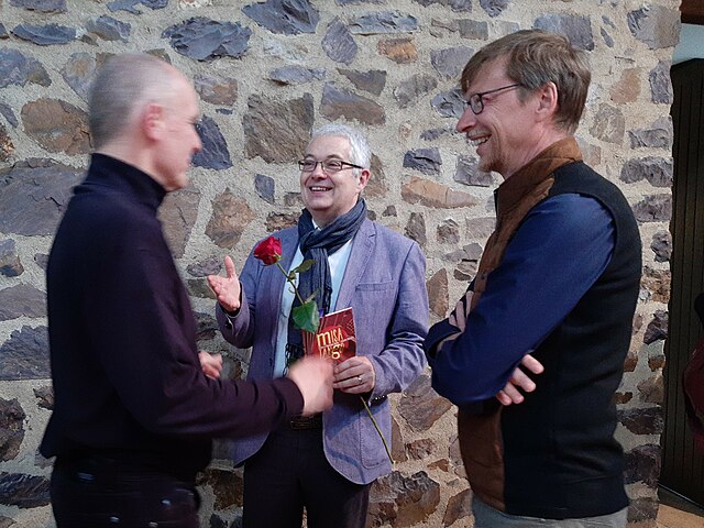Reulein (centre), talking after a performance of his Te Deum at St. Martin, Idstein, to Franz Fink (left) who conducted and Roman Twardy on 7 May 2023