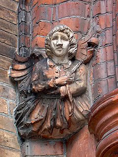 Angel at St. Andrew's holding a thistle, symbol of Scotland. Other angels at the church hold a rose, shamrock, and a leek, the symbols of England, Ireland, and Wales StAndyThis2.JPG