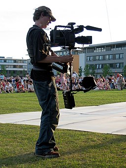 Steadicam and operator in front of crowd. Public domain image.