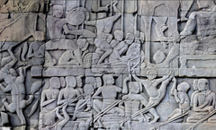 Bas-relief at the Bayon(12th/13th century). In the upper left corner, a martial artist uses a thrust kick on his opponent. In the lower right corner, a martial artist demonstrates a high kick.