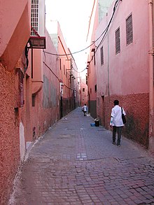 A street in the Medina of Marrakech, showing the "wall" effect of agglutinated buildings and the absence of lower floor windows. Street Wall Early Cities.jpg