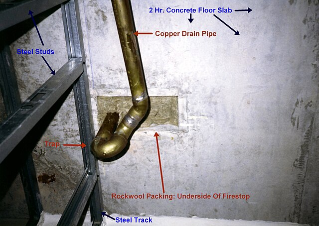 Trap with copper drain pipe at underside of firestop packing in two-hour fire-resistance rated concrete floor slab