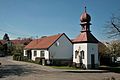 Čeština: Obec Vidonín v okrese Brno-venkov. Zvonice s křížem a domem č. 17 na křižovatce v obci. This is a photo of a cultural monument of the Czech Republic, number: 27592/7-4608. Památkový katalog  · MIS  · hledat obrázky  · hledat seznamy  · Wikidata