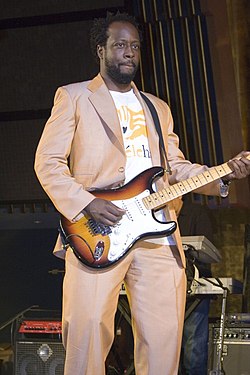 Wyclef Jean gitározik egy koncerten.