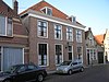 Huis met gepleisterde, vier traveeën brede, lijstgevel