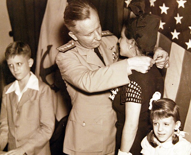 Rear Admiral Andrew C. Bennett, Commandant, Eighth Naval District, bestows the Medal of Honor upon the widow of Howard W. Gilmore.