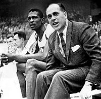 The Celtics seated on the bench, with Auerbach at the fore