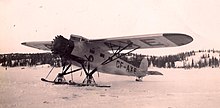 Canadian Airways Fairchild 82A CF-AXE on the goldfields in 1938. The skis have been set over some logs to prevent them from freezing to the surface CF-AXE ski plane (10841680165) (cropped).jpg