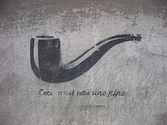 Rene Magrite's The Treachery of Images, a painting of a pipe with the text "Ceci n'est pas une pipe" written underneath, spraypainted in black on a concrete wall.