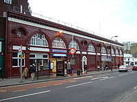 A red-bricked building with a blue sign reading "UNDERGROUND" in white letters such that the "U" and the "D" are larger than the rest of the letters