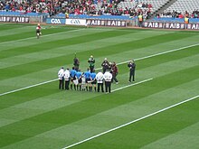 Hurling referee and linesmen in blue shirts, umpires wear white coats Croke Park referees.jpg