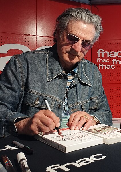 Auteuil signing a copy of Caché in 2023