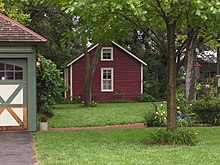 The 1871 wood-frame cabin in the front yard Hans Hanson house.jpg