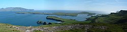 Panorama de Sanday (desde la colina de la Boussole, en la isla de Canna). Al fondo, la isla de Rùm. Todas estas islas están bañadas por el mar de las Hebridas.