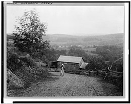 A woman walks up a hill in Dingmans Ferry, 1897 Landscape with woman walking up hill, barn below, and rail fence along road, at twilight, Dingman's Ferry, Pennsylvania LCCN93508312.jpg