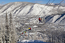 Skiers and snowboarders ride up the iconic Lift 1A on Aspen Mountain with downtown Aspen in the background. Lift 1A on Aspen Mountain.jpg