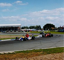 Nigel Mansell gives Ayrton Senna a lift back to the pits on his victory lap after winning the 1991 British Grand Prix. Mansell and Senna at Silverstone.jpg