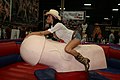 Una donna in groppa ad un grande toro meccanico di forma fallica all'Exxxotica di New York 2009
