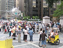 Tourists gather around a busker in Columbus Circle
