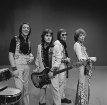 Examples of Teddy Boy clothing worn by Ray Stiles and Les Gray of 1970s glam rock band Mud: drape jackets, brothel creepers and drainpipe trousers (source: AVRO) Mud - TopPop February 1974 03.png