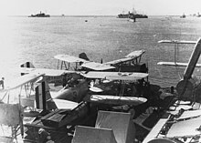1933: Vought O3U-1 "Corsair" observation planes aboard the Augusta during exercises in Subic Bay. O3U-1 Corsairs on a barge alongeside of USS Heron (AM-10) in Subic Bay, circa in 1933 (NH 51872).jpg