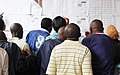Électeurs cherchant leurs noms sur les listes pour trouver leurs bureaux de vote