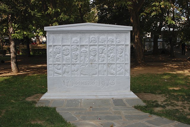 Monument blanc représentant un grand nombre de personnes dans une geôle sous laquelle est inscrite, en grec, la date du 17 novembre 1973.