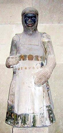 1250 statue of Saint Maurice in the Magdeburg Cathedral, Germany, wearing a coat of plates above his Hauberk and with a mail coif on top. Saint Maurice Magdeburg.jpg