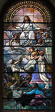 Esta janela de vitral mostra dois anjos carregando uma criança pequena em direção a Cristo sentado em nuvens douradas enquanto um grupo de pessoas abaixo está assistindo.