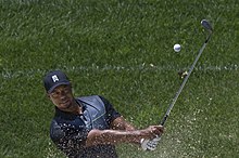 Woods practicing in a bunker prior to the start of the 2014 Quicken Loans National Tiger Woods 2014.jpg