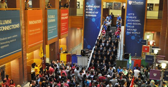 Wharton undergraduate students with cohort banners