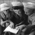 ילדים במחנה בקפריסין קוראים יחד מאותו ספר בגלל המחסור בספרים. 1947.-PHKH-1284207.png