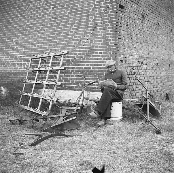 File:Annexatie Boer leest krant bij een hoek van zijn boerderij, omgeven door landbo, Bestanddeelnr 900-6310.jpg