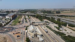 Luftbild 2020 mit Bahnhof Aschdod – ʿAd Ha­lom (vorn), Anschlussstelle gleichen Na­mens, BIG Fashion vor Busdepot und Park ʿAd Halom (obere Mitte rechts) am Nachal Lachisch