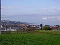 Vista geral da ria de Ferrol, a partir de Barallobre. Ao fundo, o estaleiro da EN Bazan e a cidade de Ferrol. À esquerda, fabrica de gás de Reganosa e os cais de Barallobre e Maniños.
