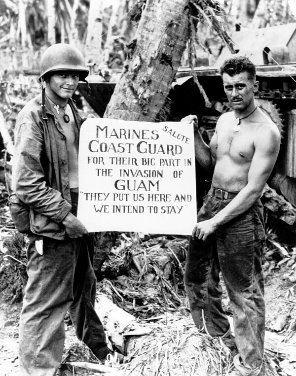 Marine Corps Privates First Class William A. McCoy and Ralph L. Plunkett holding a sign thanking the Coast Guard after the Battle of Guam in 1944