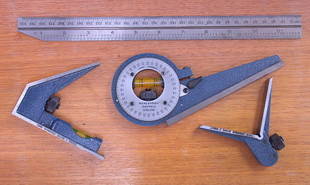 A combination set with the rule (top), a standard head (left), protractor head (centre), and a centre finder head (right).