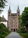 A grey stone cathedral with two towers topped with pyramidal spires.