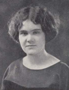 A young white woman with cropped, dark, wavy hair