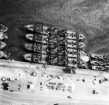 USS Appling (APA-58) lies outboard (top) of sister ships Barrow (APA-61), Brule (APA-66) and Gasconade (APA-85), at the Pearl Harbor Naval Shipyard, 27 February 1946, as they are readied for Operation Crossroads. Gilliam-class attack transports at the Pearl Harbor Naval Shipyard, Hawaii (USA), on 27 February 1946 (80-G-361735).jpg